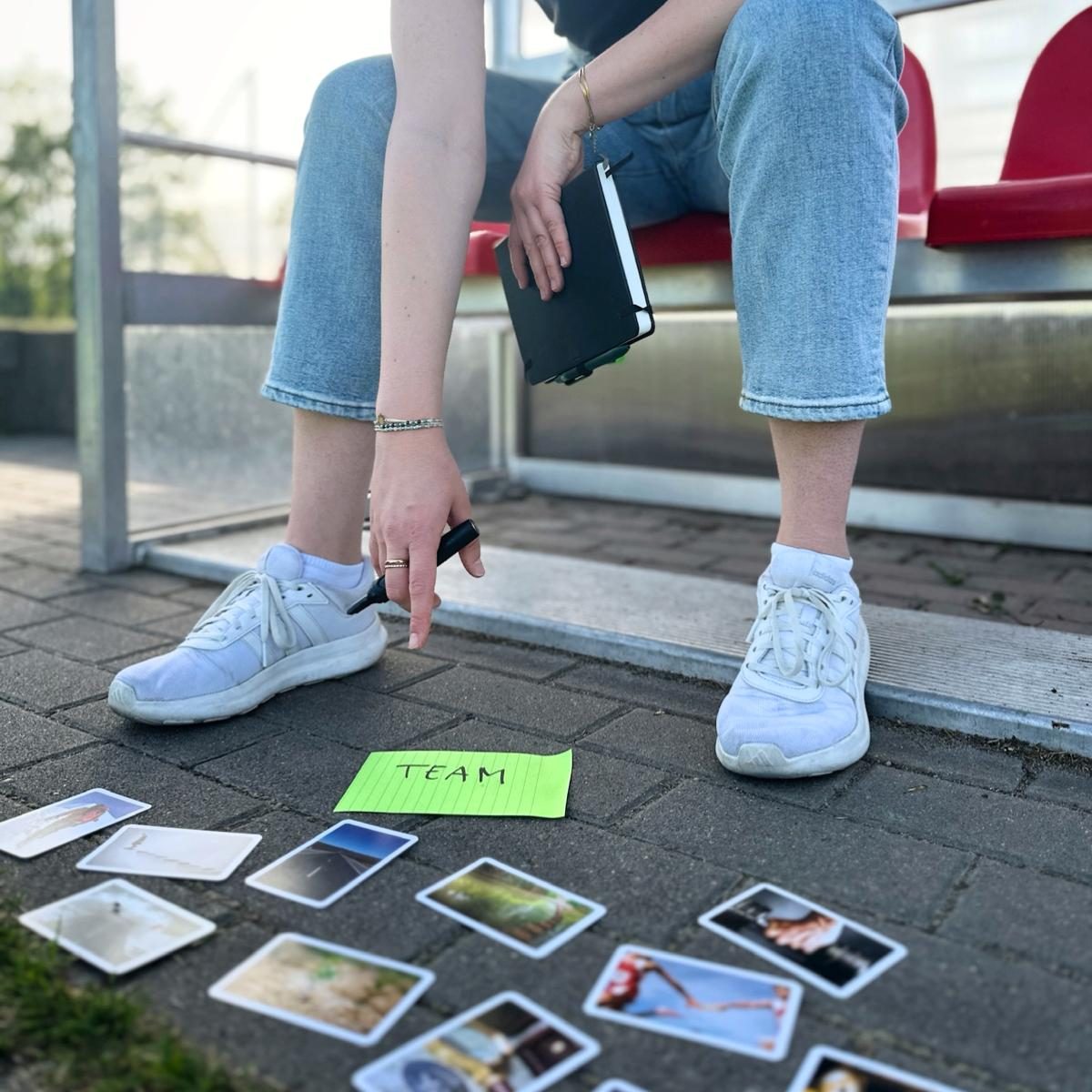 © Nicole Flechs Bild in einer Spielerkabine auf einem Sportplatz mit dem Fokus auf einem Zettel auf dem Team steht